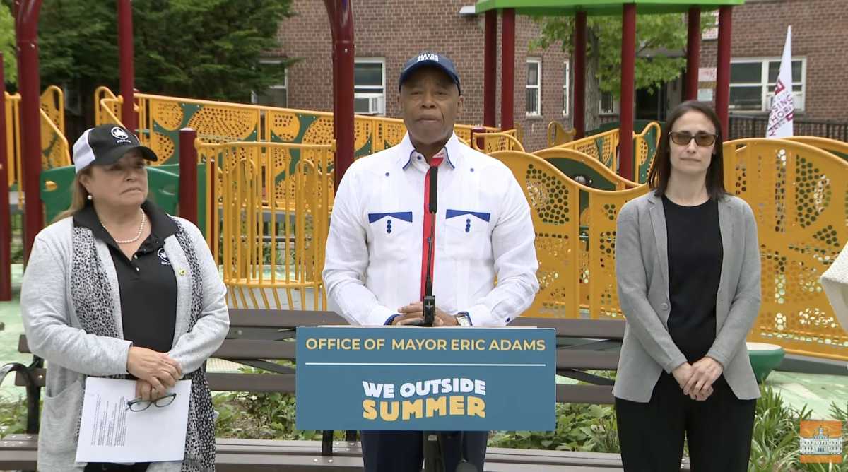 three people in front of a playground on NYC Parks property
